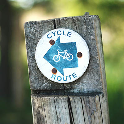 a wooden signage showing the direction for the cycle route