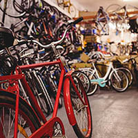 close up of a red bicycle in the foreground with many bicycles displayed in the background that are not in focus