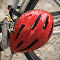 red cycling helmet hanging off from a handle of a bicycle