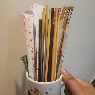 A mug filled with various chopsticks